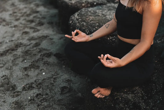 Frau am Strand, die Yoga praktiziert